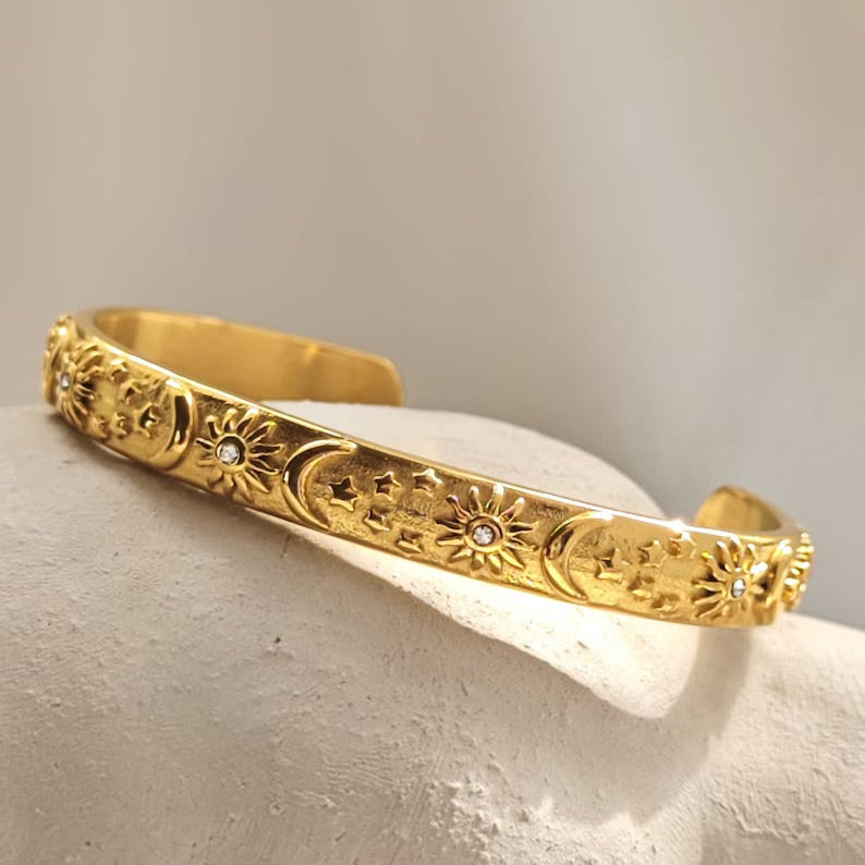 Bangle bracelet layered with other bracelets