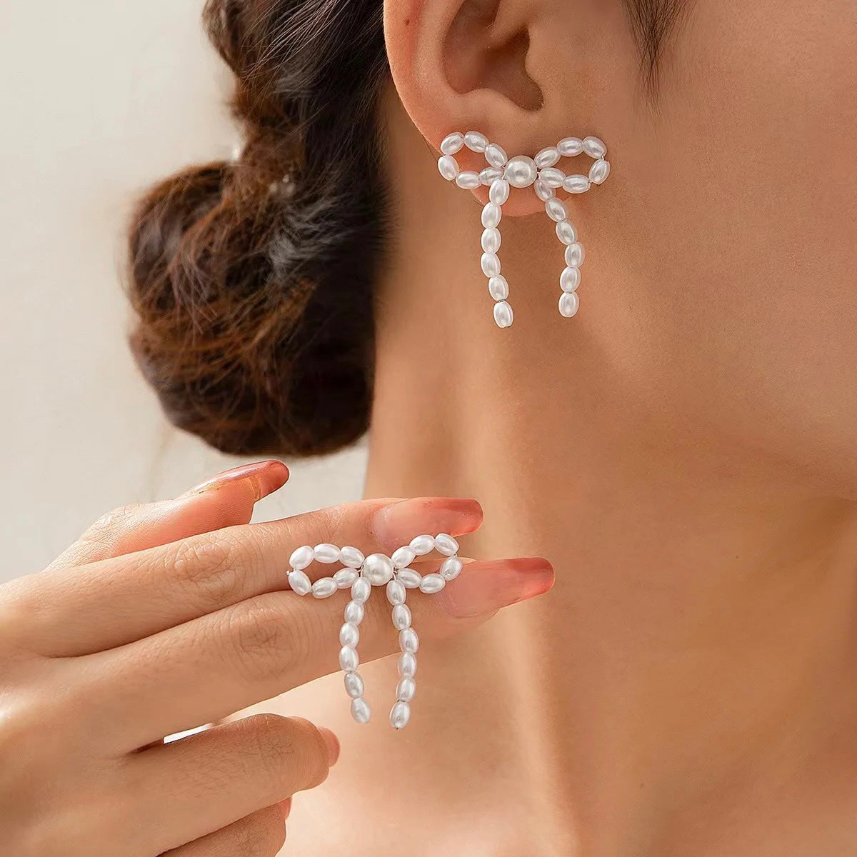 Pearl bow earrings worn on ear – styled for elegance