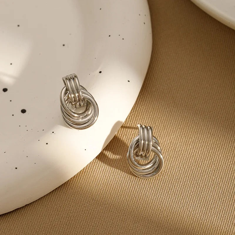 Close-up showing the smooth texture and shiny finish of knot earrings