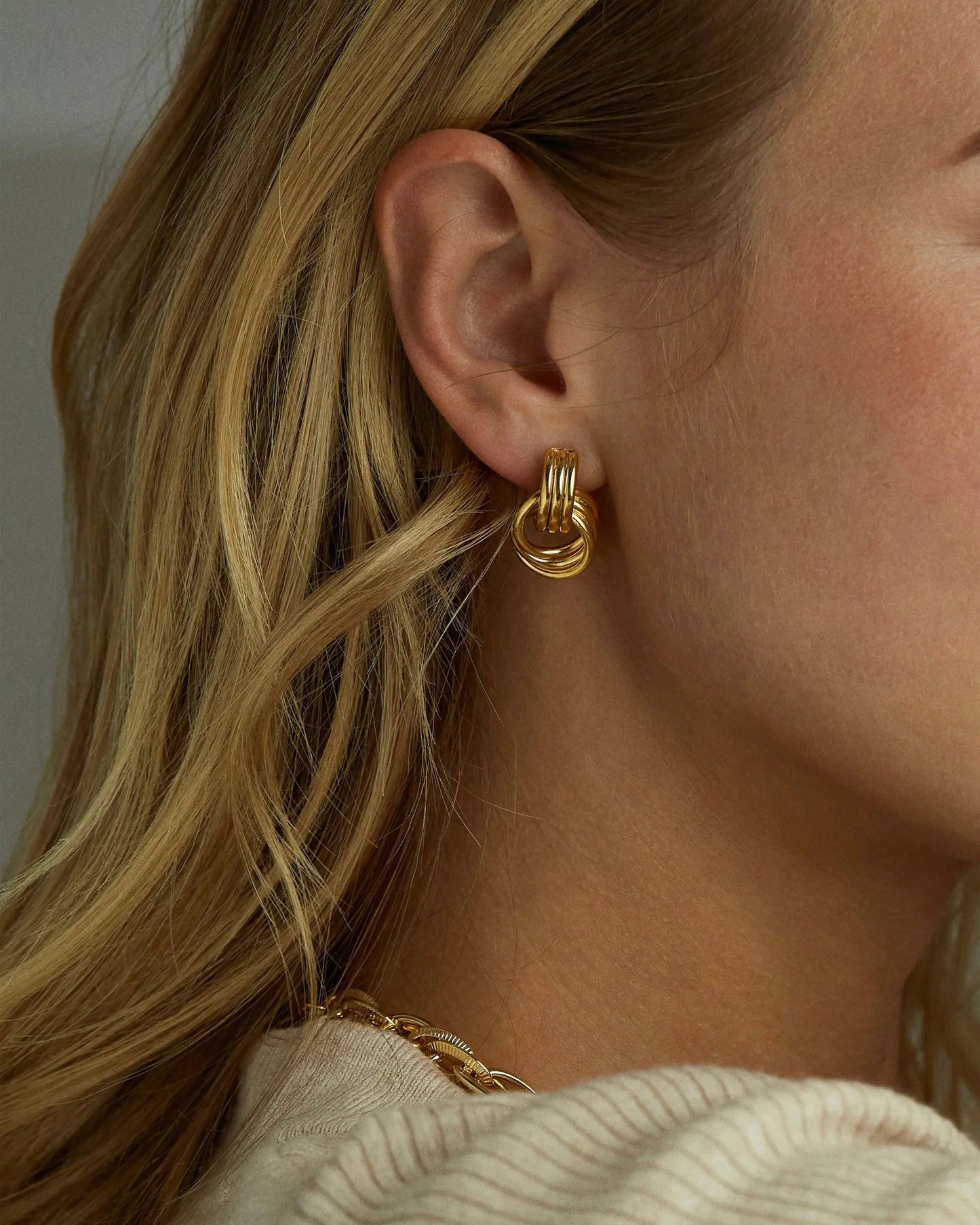 Daily wear flatlay featuring Clean Knot earrings and beauty items