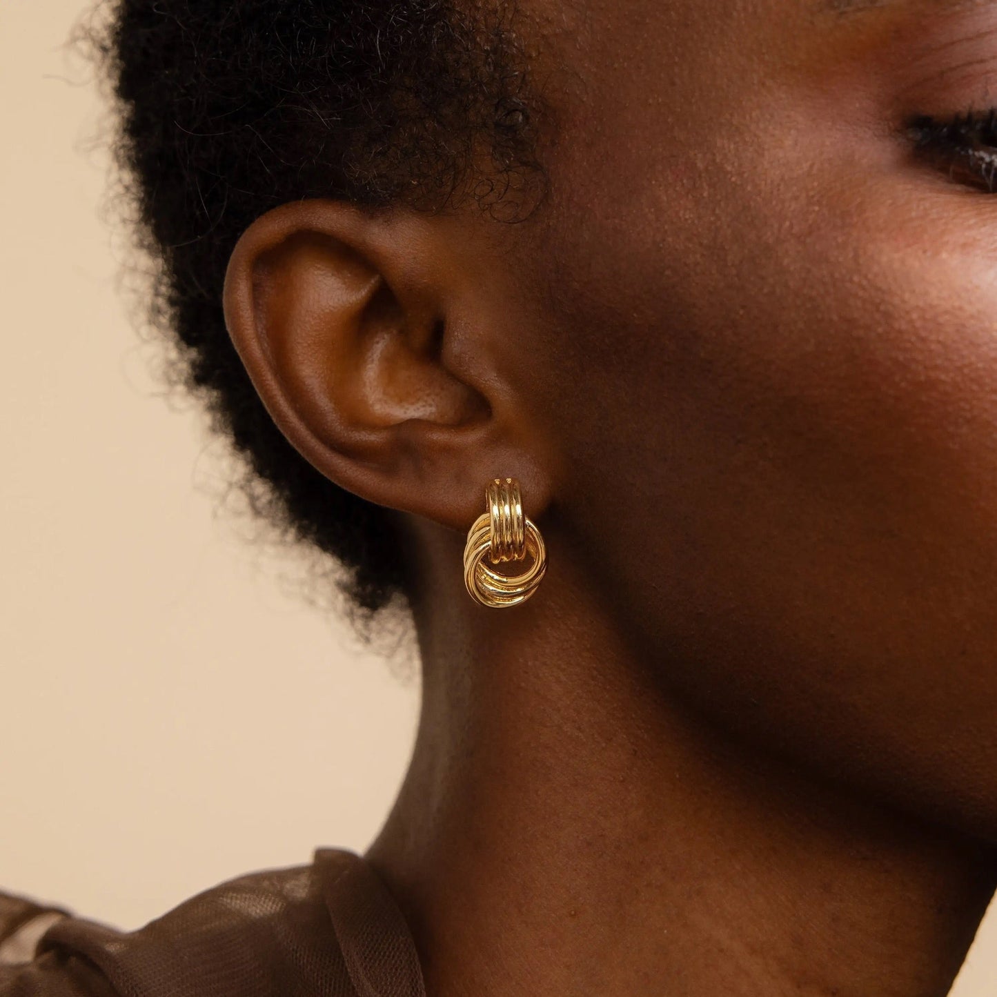 Side-by-side comparison of Clean Knot earrings in gold and silver
