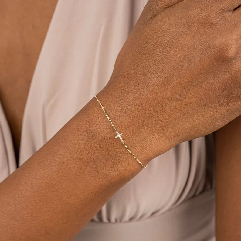 Cross bracelet with gold finish worn on wrist