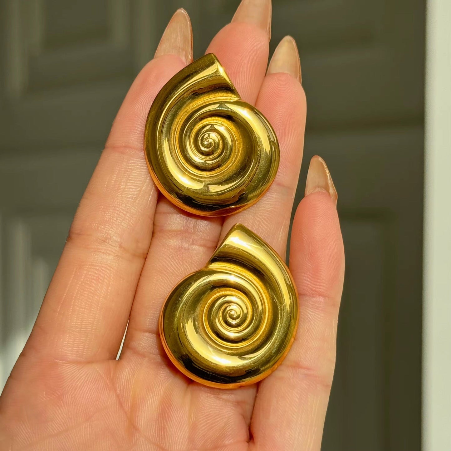 Dainty conch shell earrings worn in a summer look