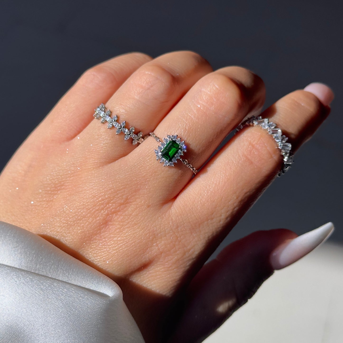 Close-up of green emerald or red garnet stone on vintage halo ring