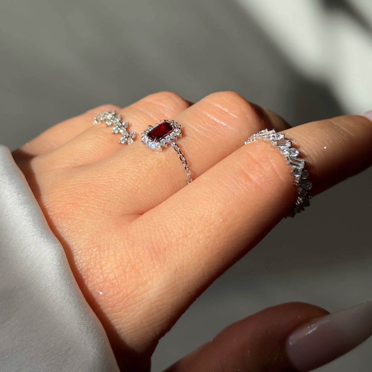 Close-up of green emerald or red garnet stone on vintage halo ring