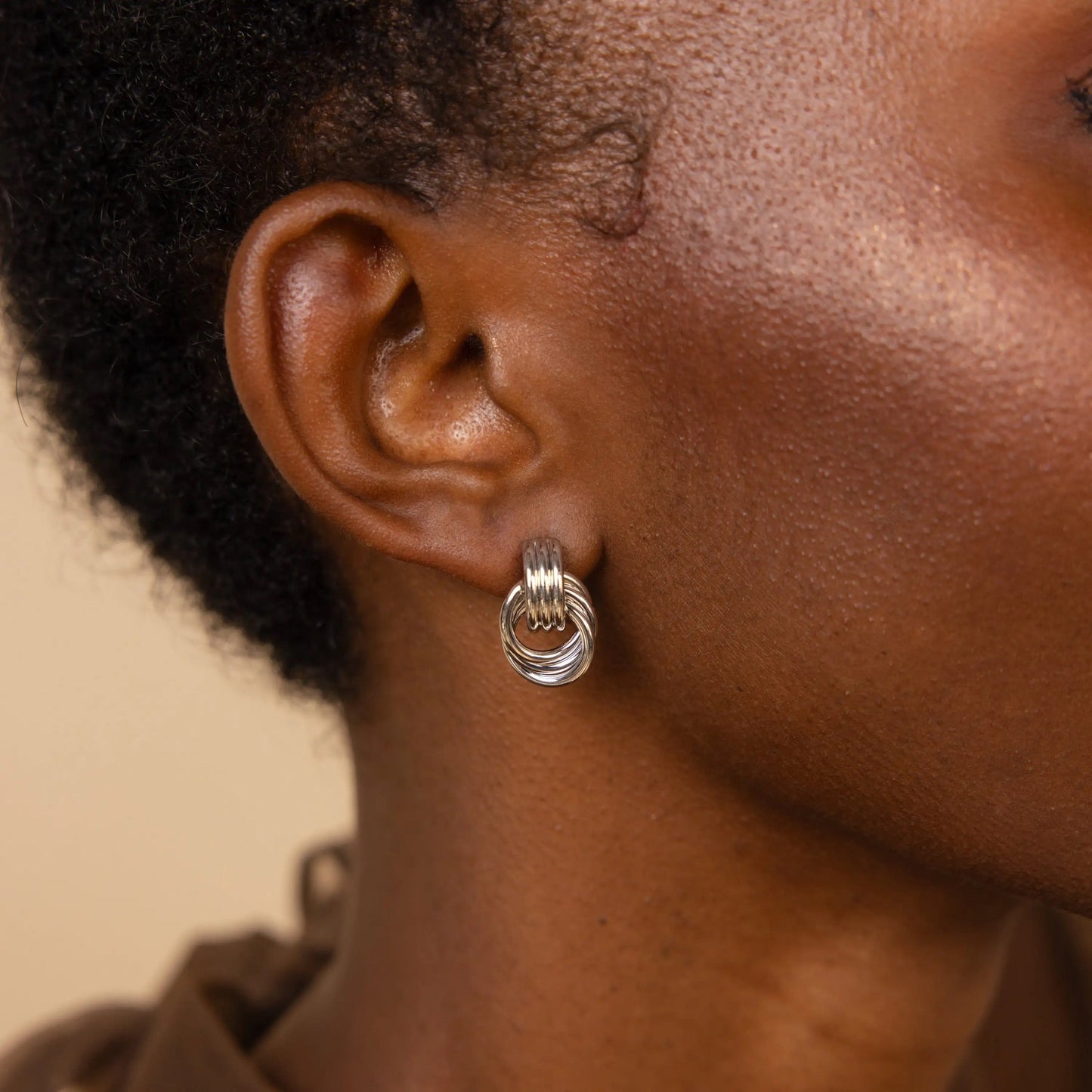 Side view of geometric knot earrings in gold and silver
