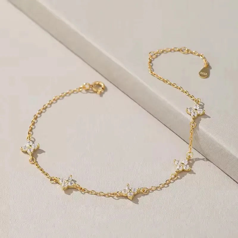Gold clover bracelet sparkling under sunlight
