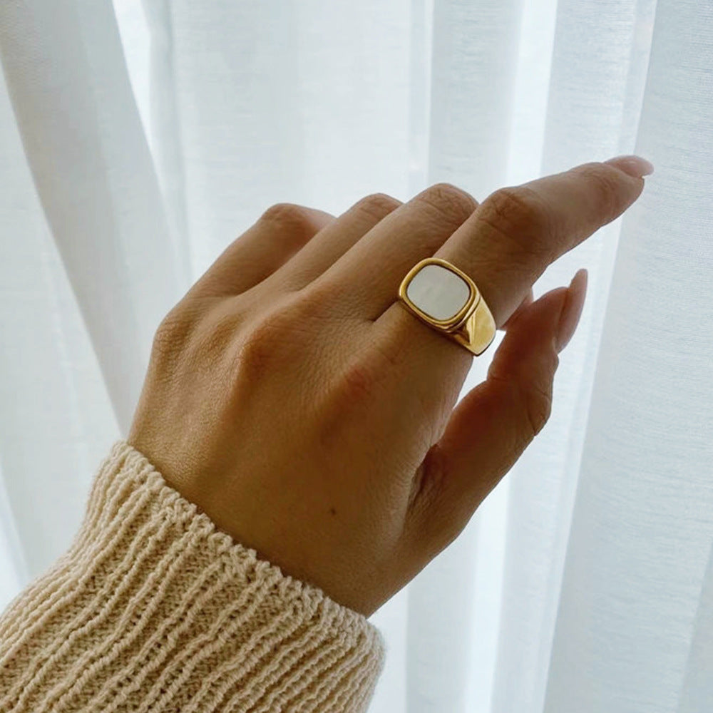 Shell ring with white gemstone worn on hand