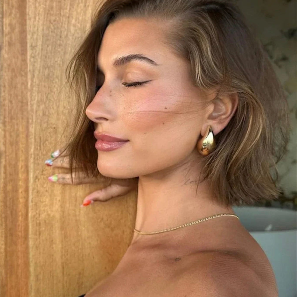 Droplet earrings styled with multiple ear piercings