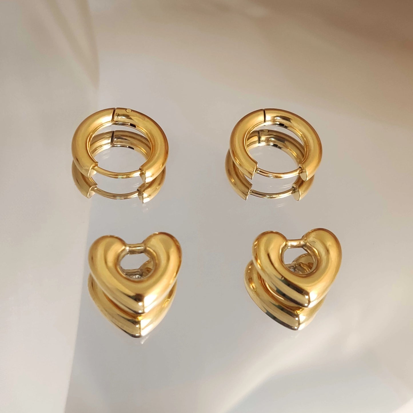 Heart huggie earrings worn asymmetrically