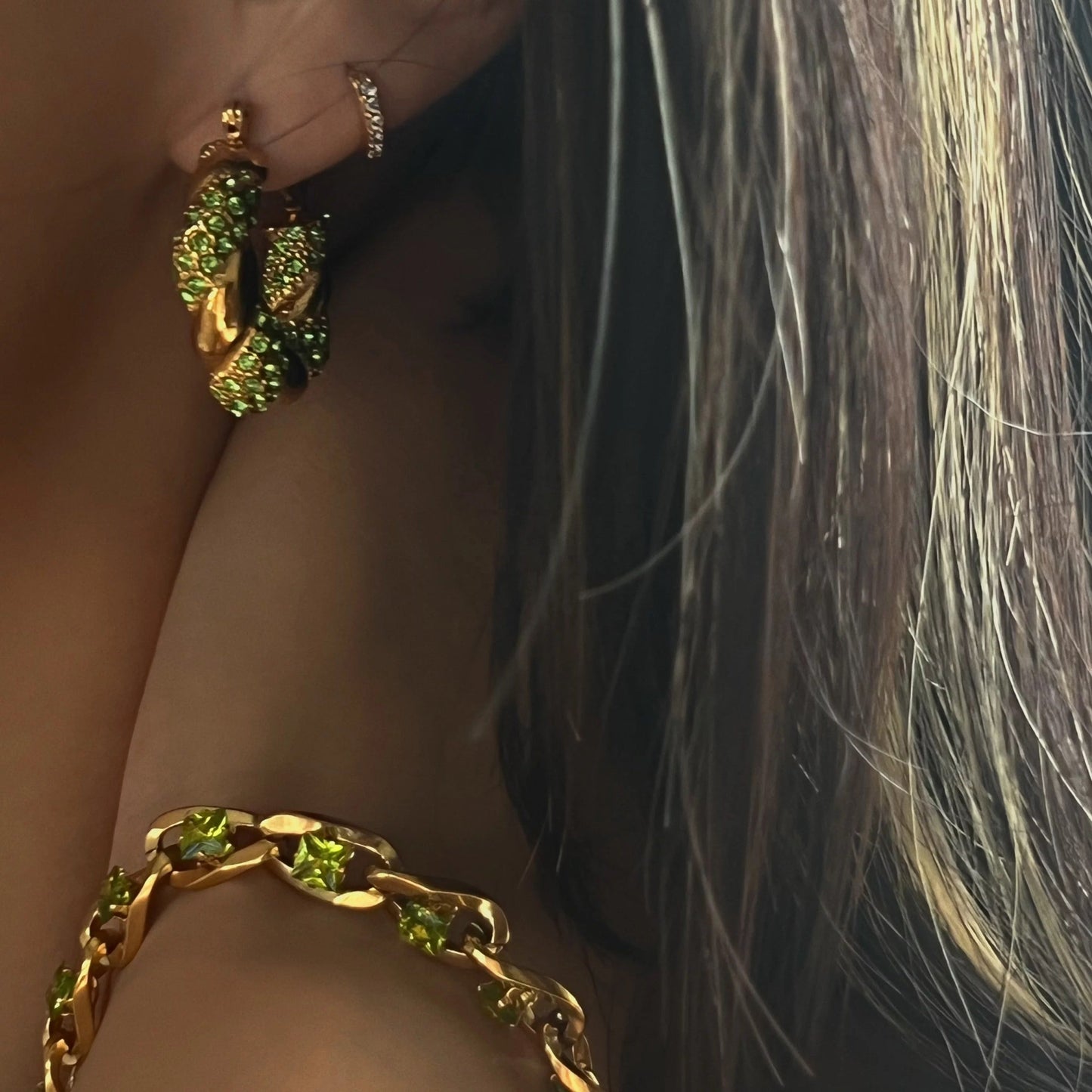 Close-up of MADDIE hoops with lime green CZ held in hand