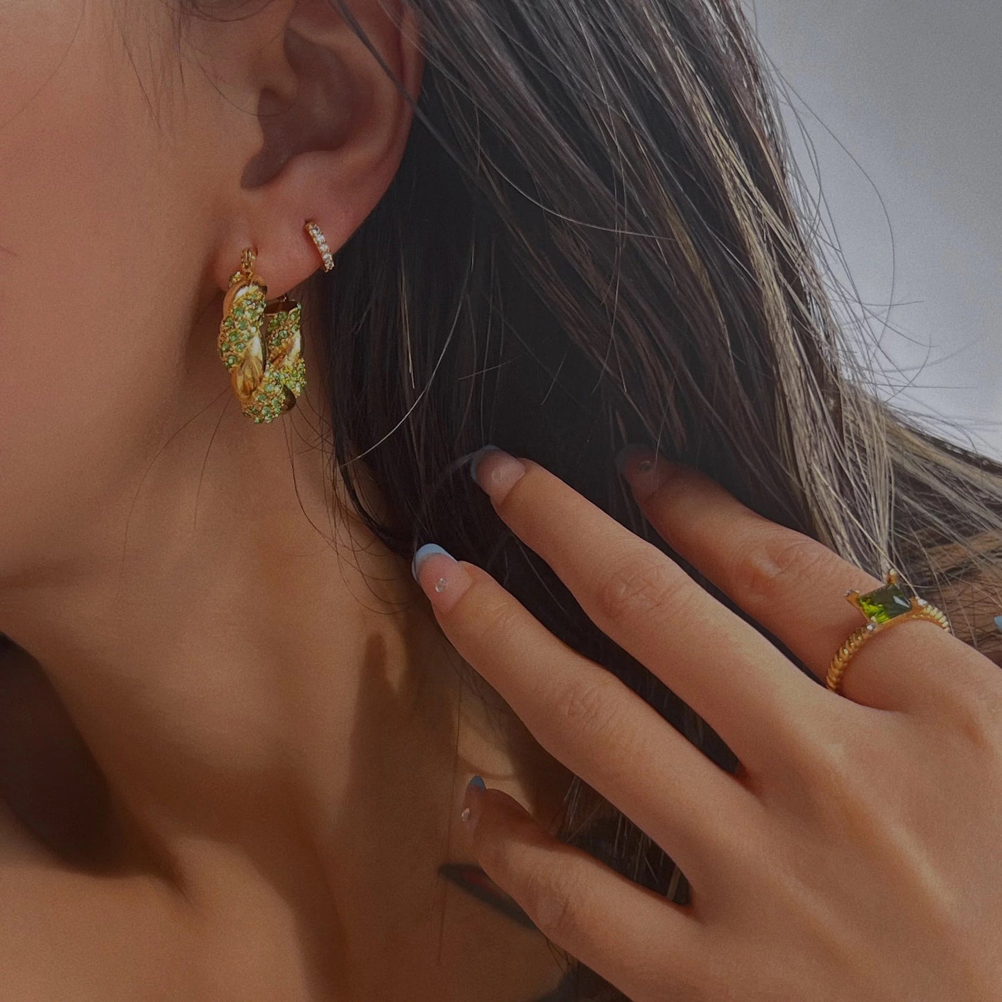 Flatlay of MADDIE pave hoop earrings with lime green CZ