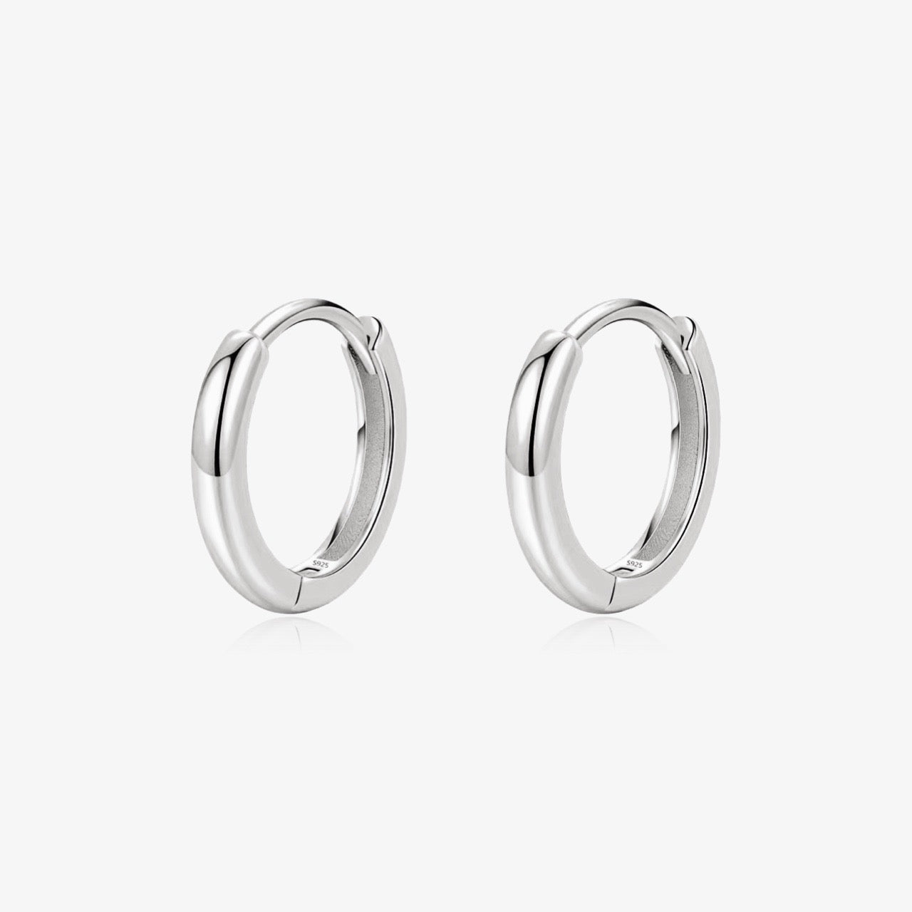 Model wearing Mini Huggie Hoop earrings in gold
