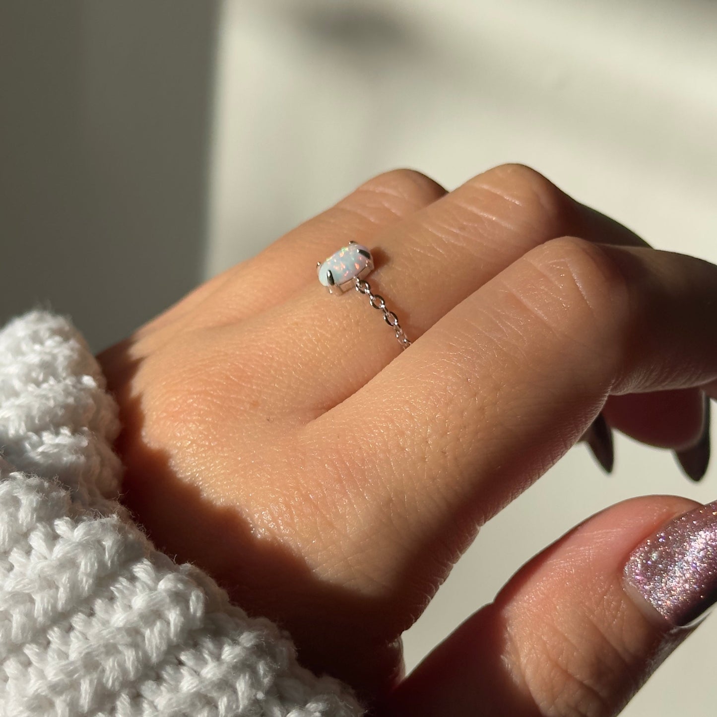 Model wearing dainty white opal adjustable chain ring