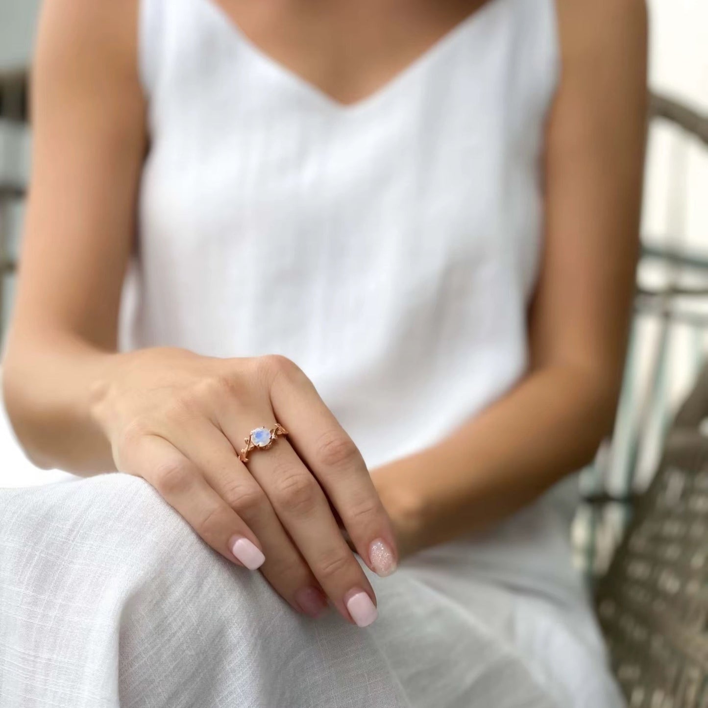 Moonstone ring layered with other dainty jewelry