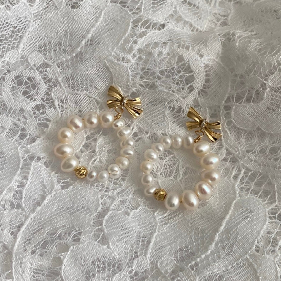 Close-up of pearl earrings with delicate bow design