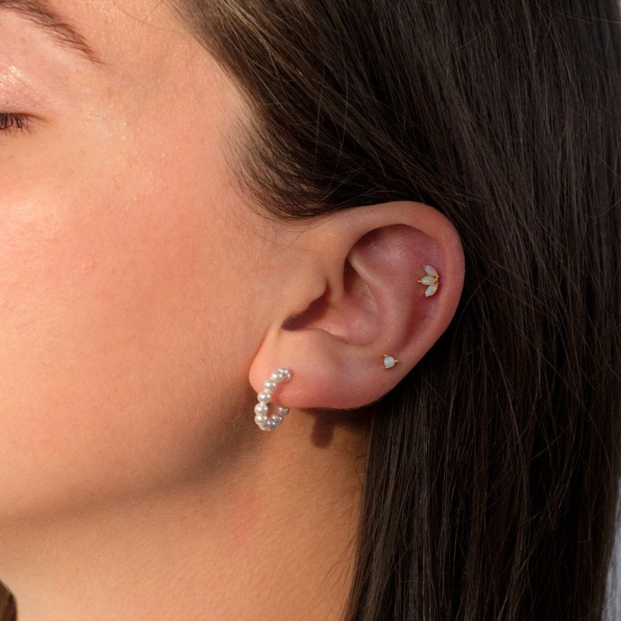 Side view of pearl drop gold hoop earrings