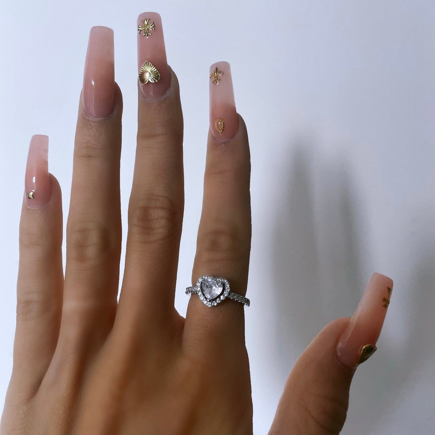 Silver heart ring layered with other dainty rings