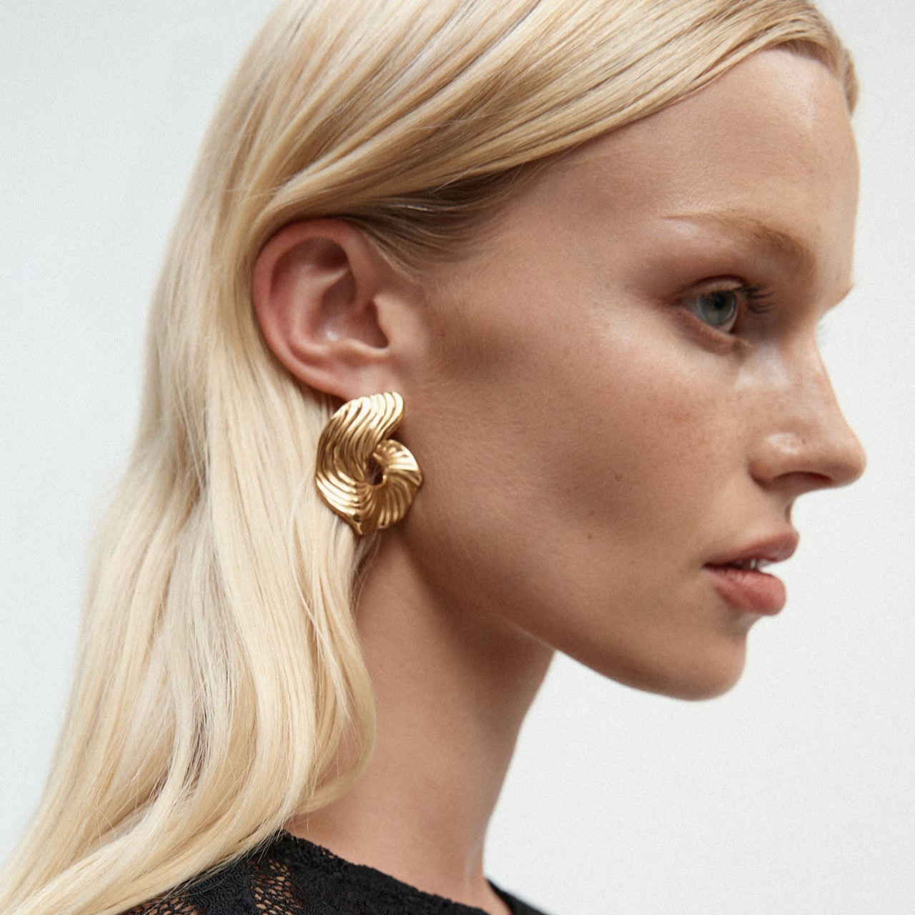 Detail of wave-shaped statement earrings