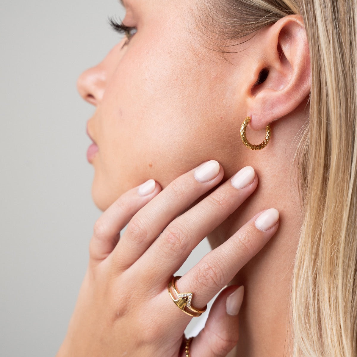 Seitliche Ansicht der Textured Huggie Ohrringe Gold