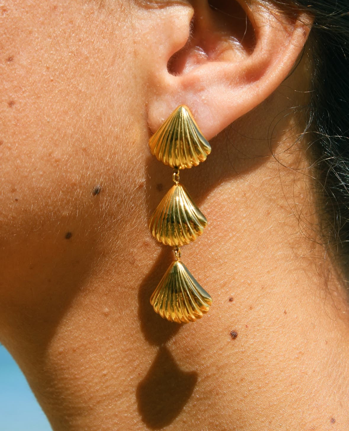 Detail of waterproof shell earrings with gold plating