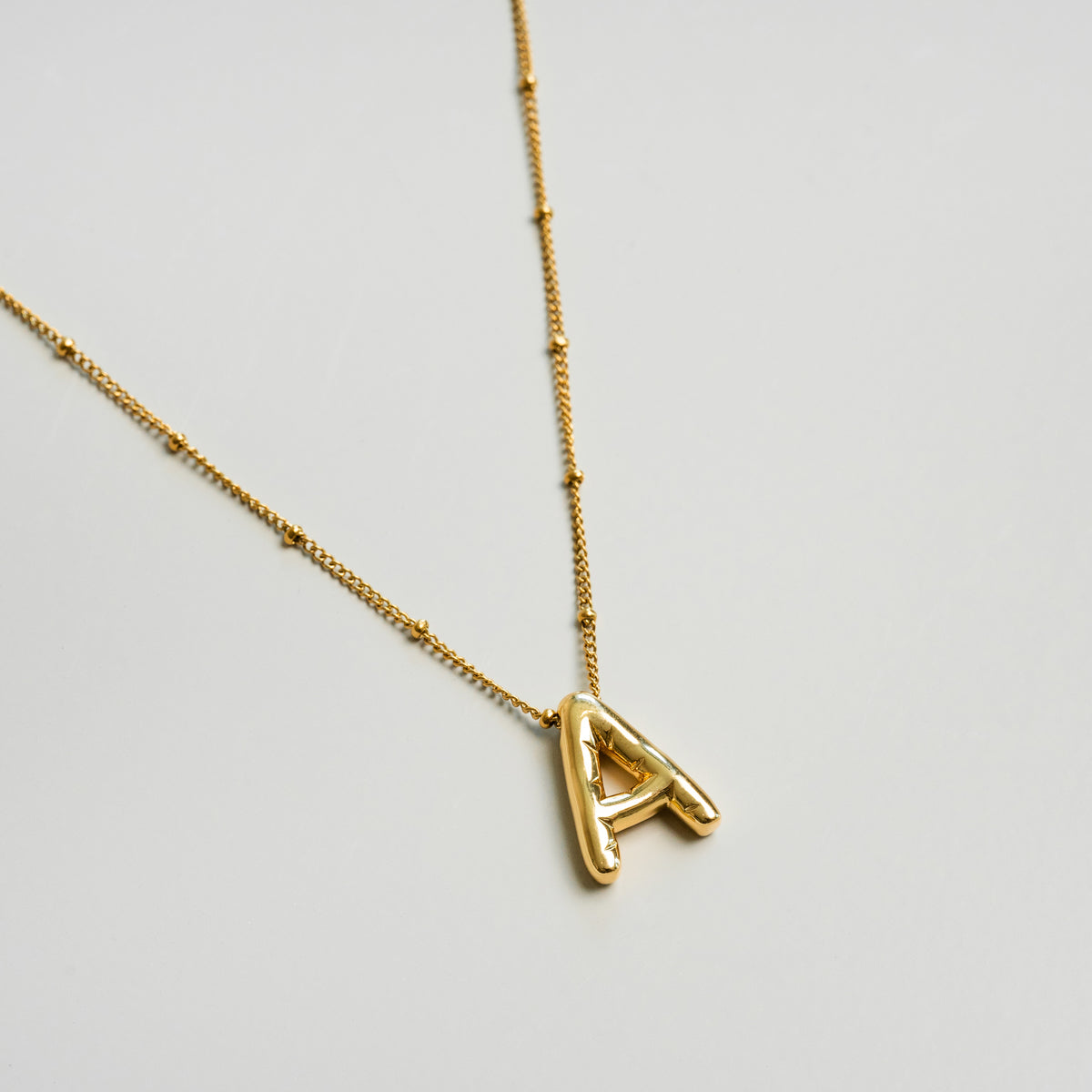 Seitliche Ansicht der Bubble Initial Halskette Gold