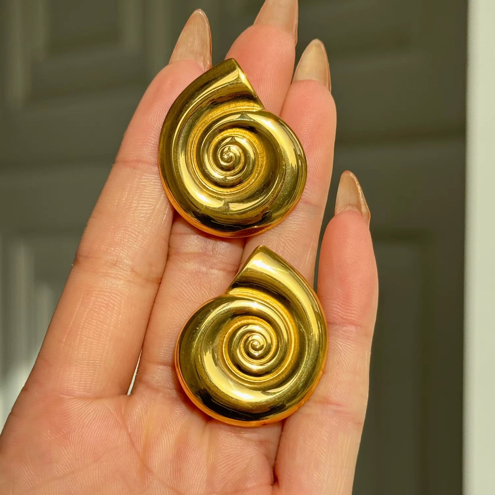 Dainty conch shell earrings worn in a summer look