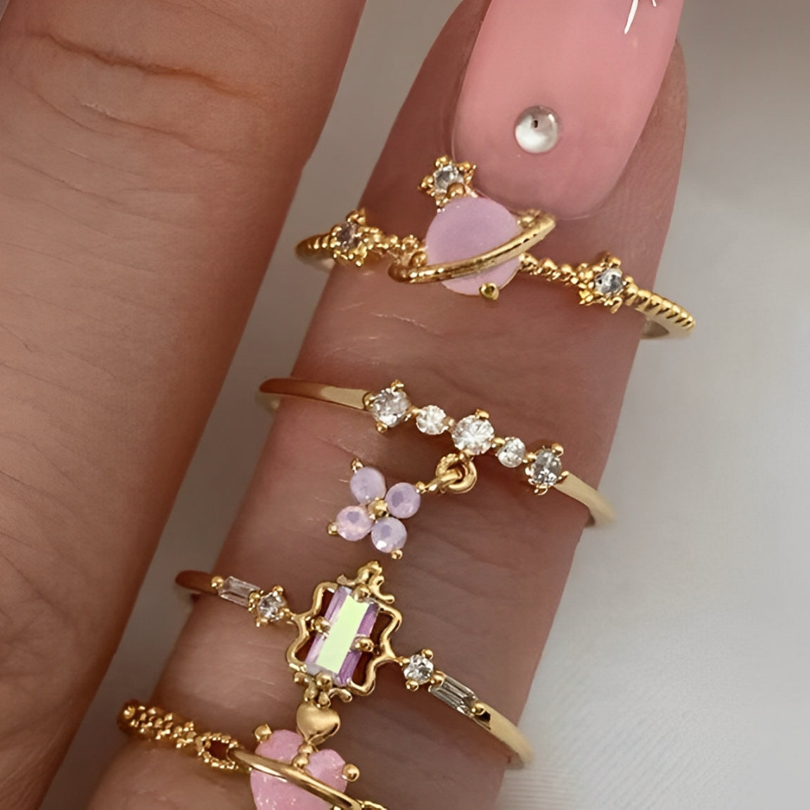 Dainty clover charm ring stacked with minimalist rings