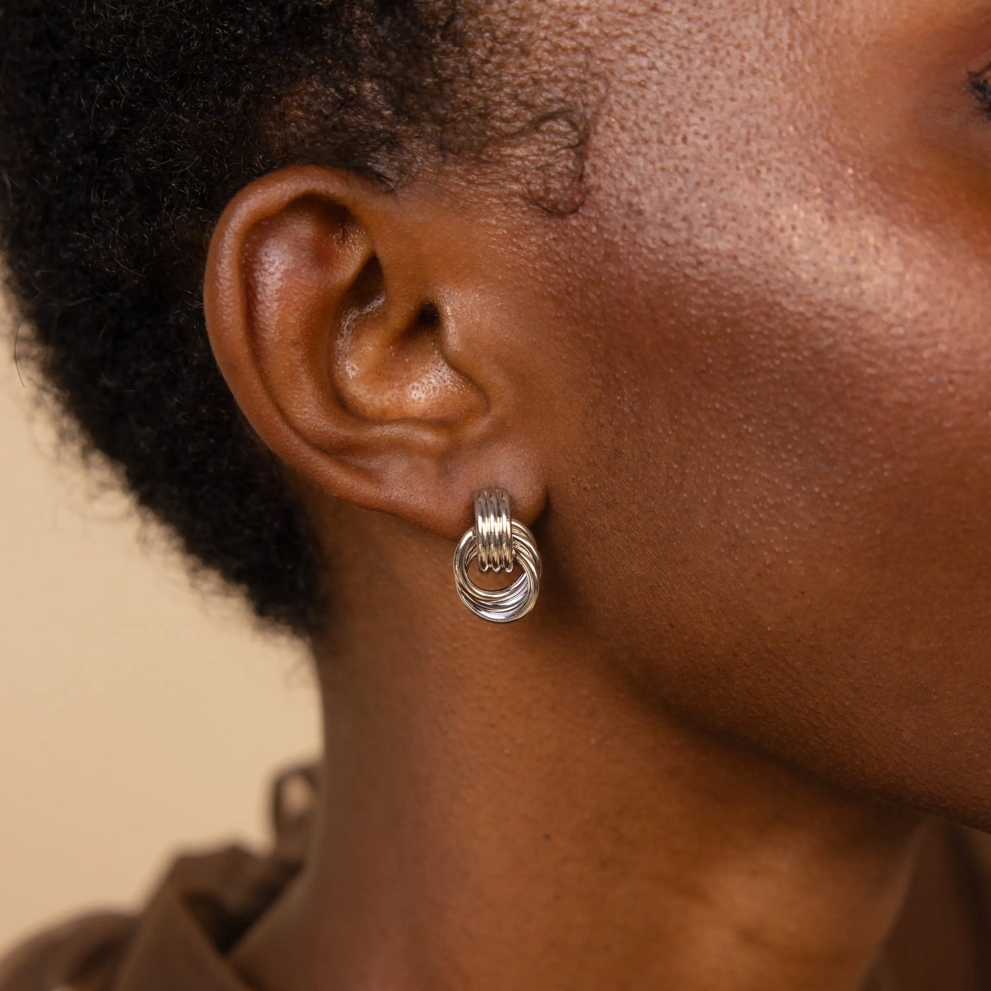 Side view of geometric knot earrings in gold and silver