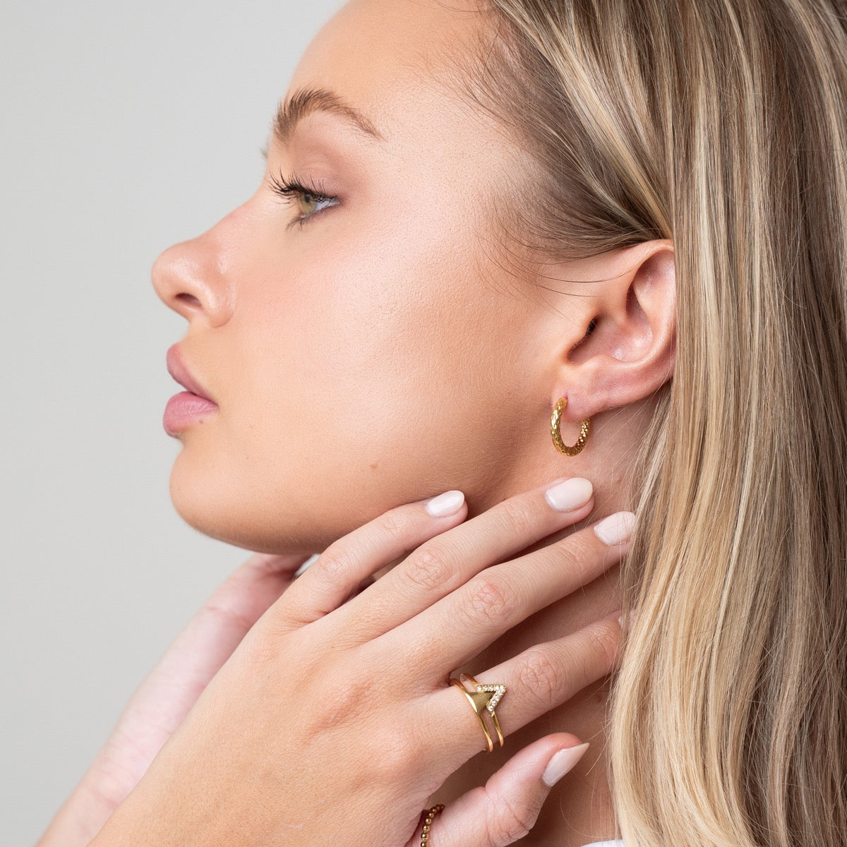 Detailaufnahme der Textured Huggie Ohrringe Gold